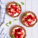 Three small Gluten-Free Strawberry Tarts filled with Greek yogurt seasoned with herbs and fresh strawberries.
